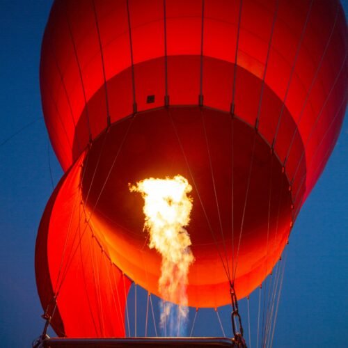 A hot air balloon inflating over the desert of Marrakech at sunrise, Atlas Mountains in the background